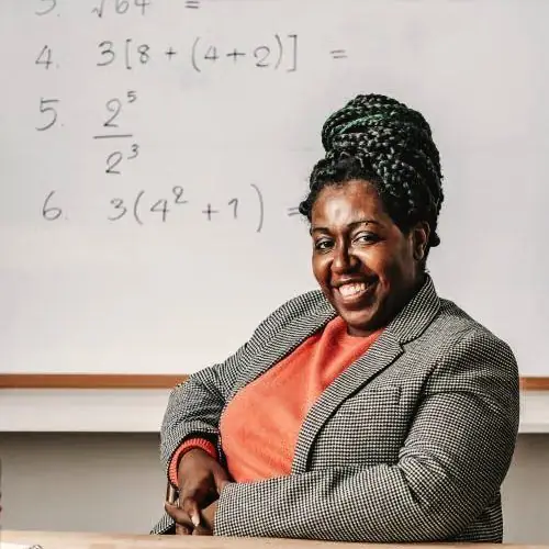 A teacher laughing mid lesson at the whiteboard